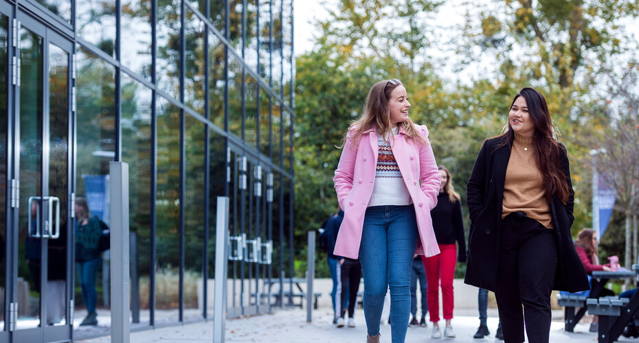 Two students walking past the Business School